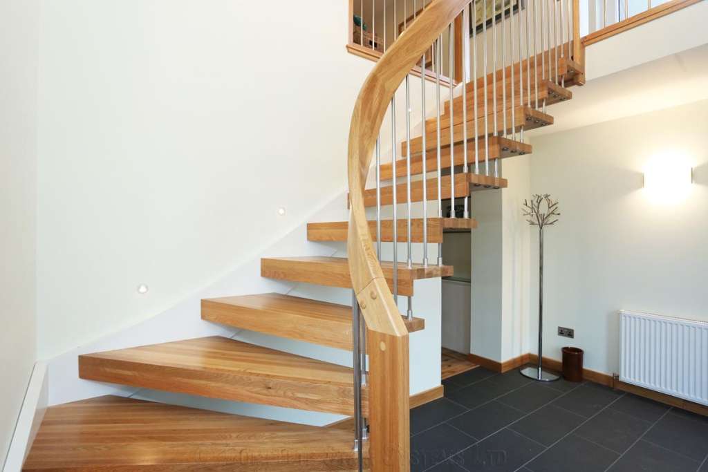 Traditional oak stairs with decorative balustrades near entryway